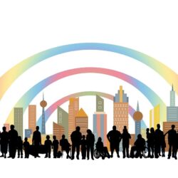 An illustration featuring a diverse group of people, including individuals with different disabilities, in front of a colorful city skyline. The group includes people of varying ages, with visible wheelchairs and other mobility aids, standing under three rainbow-colored arcs that curve above the city. The image represents inclusivity and diversity.