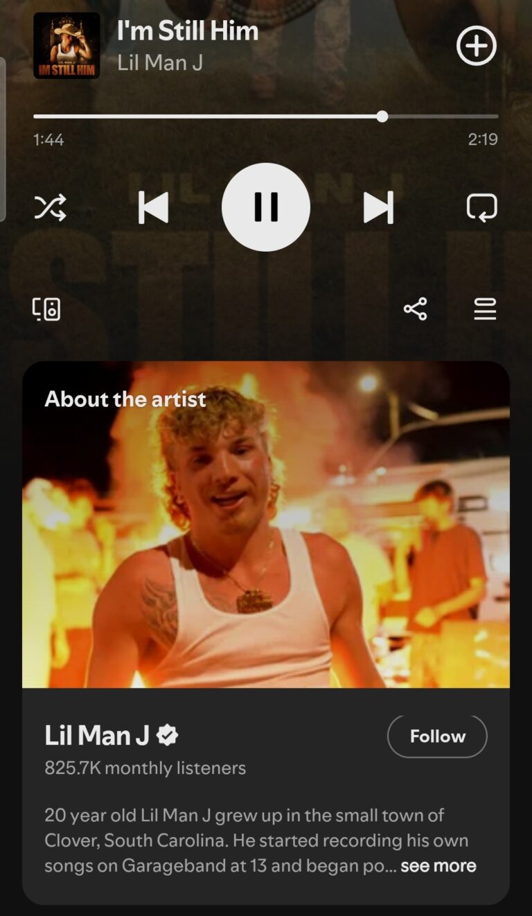 Screenshot of Spotify playing “I’m Still Him” by Lil Man J, showing the play bar and artist profile. Below is a photo of Lil Man J in a white vest, performing with flames in the background.